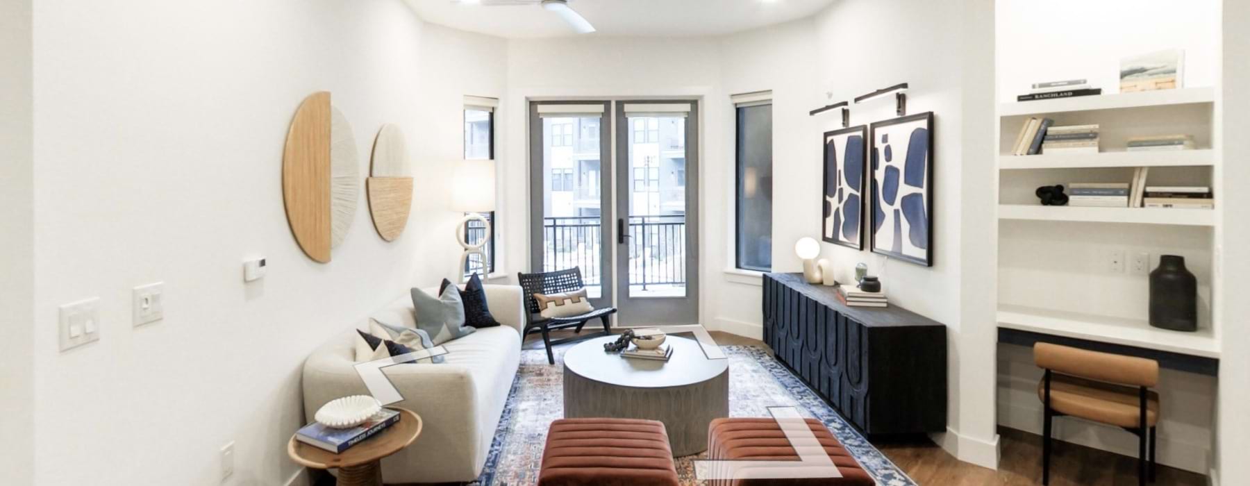 A living room area with a couch, chairs, and a coffee table at Residences at OAK apartments in Oklahoma City.